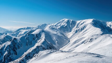 A stunning view of snow covered mountains stretches across the horizon. The bright blue sky contrasts beautifully with the white peaks. It is a serene and peaceful winter day in the mountains.