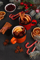 Strong alcoholic or non-alcoholic cocktail in iron mugs, mulled wine with spices, star anise, cranberries, orange, apple and cinnamon, warming winter drink in the cold season, Christmas festive grog,