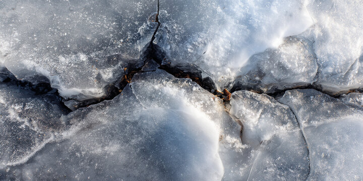 Cracked ice surface with visible textures and shades of blue  