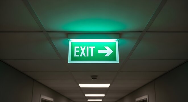 Emergency exit sign in modern office corridor with green illumination for safety and guidance