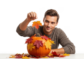 Young man decorates a vibrant pumpkin with colorful autumn leaves for fall celebration transparent background