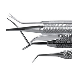 A close-up, dramatic still life of stainless steel dental instruments against a stark black background.