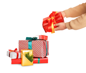 Hands placing a red and yellow wrapped gift box onto a large colorful stack of holiday presents, isolated on white background.