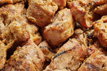 Close-up of grilled shashlik kebab pieces in a foil tray