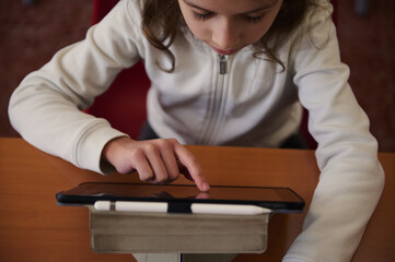 Child Using Tablet In Library For Learning And Education Focused On Knowledge At School