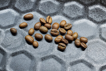 Close-up of a group of roasted coffee beans on a black baking tray background