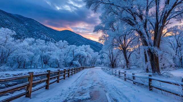 winter road with wooden fence at sunrise, frosty trees along quiet snowy path
