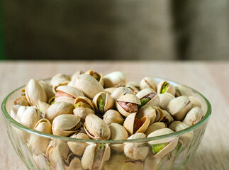 Bowl full of pistachios - Glass Bowl Overflowing with Roasted and Salted Pistachio Nuts