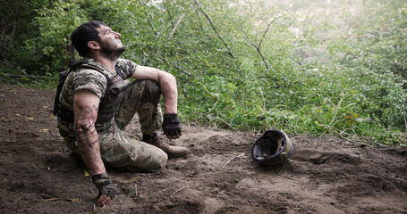 Obraz premium Young soldier sitting on the ground