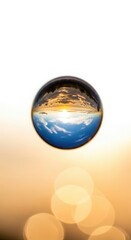 Crystal clear water droplet reflecting a vibrant sunset sky and ocean