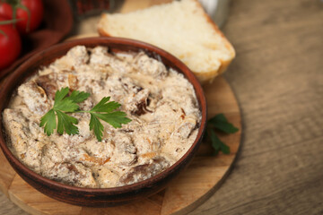 Tasty beef Stroganoff with parsley served on wooden table, closeup. Space for text