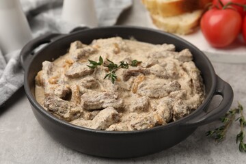 Tasty beef Stroganoff with thyme served on grey table, closeup