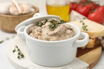 Tasty beef Stroganoff with thyme in casserole and ingredients on table, closeup