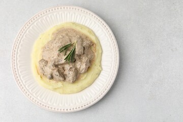 Delicious beef stroganoff with mashed potatoes and rosemary on light table, top view. Space for text