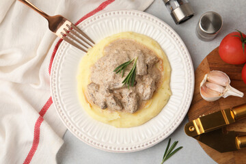 Delicious beef stroganoff with mashed potatoes and rosemary served on light table, flat lay