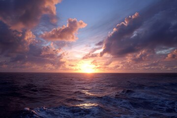 Vibrant sunset over open ocean with dramatic clouds and shimmering waves at twilight