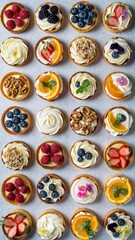 Assorted mini tarts with fresh fruits and cream: a colorful display of delicious pastries