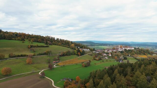 Flight over autumn forest near Zurich with medieval town of Regensberg
