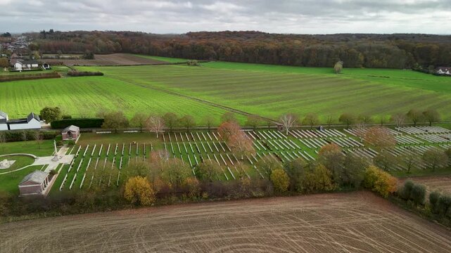 Aerial view of Hooge Crater Cemetery in Flanders, located on major World War I battlefields near Ypres, showing aligned war graves and surrounding rural landscape.