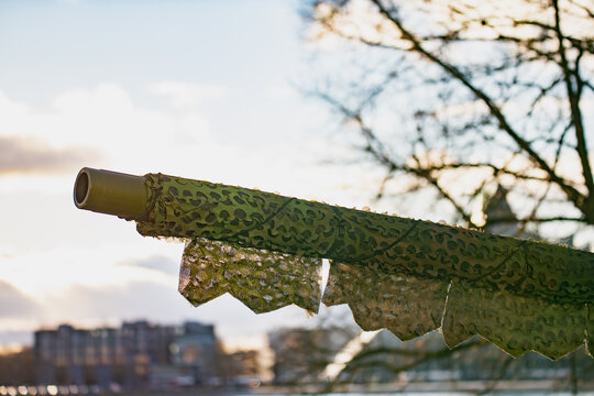 NATO battle tank gun shrouded in camouflage netting illustrating advanced concealment tactics, strengthened alliance deterrence capability, and evolving geopolitical defense dynamics