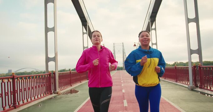 Women runners share thoughts on latest workout routines on bridge
