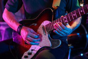 Man playing electric guitar on stage, closeup