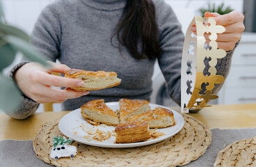 A young girl holds a galette and a crown in her hands.