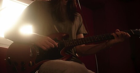 Rock musician strumming electric guitar in recording studio - Powered by Adobe