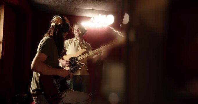 Two male musicians playing electric guitars in a recording studio