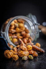 Nuts coated in sugar glaze on black table.