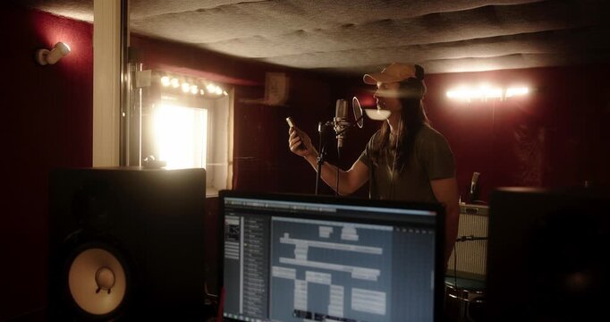 Female singer reading lyrics on phone in recording studio