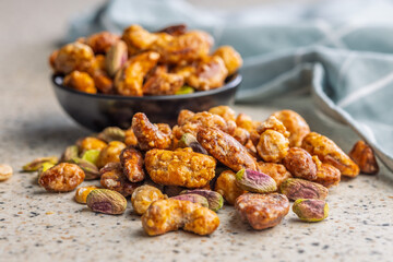 Nuts coated in sugar glaze on kitchen table.