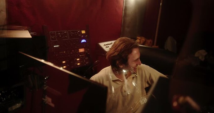 Audio engineer listening and mixing music in a professional recording studio