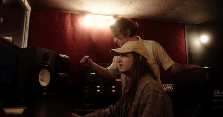 Music producers working together in a recording studio creating a new song