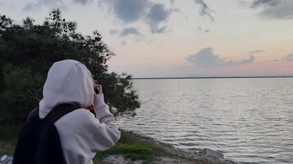 Izmir, Turkey - Nov 20 2025: Woman with camera photographs flamingos at Sasalı Bird Paradise in Gediz Delta wetland area