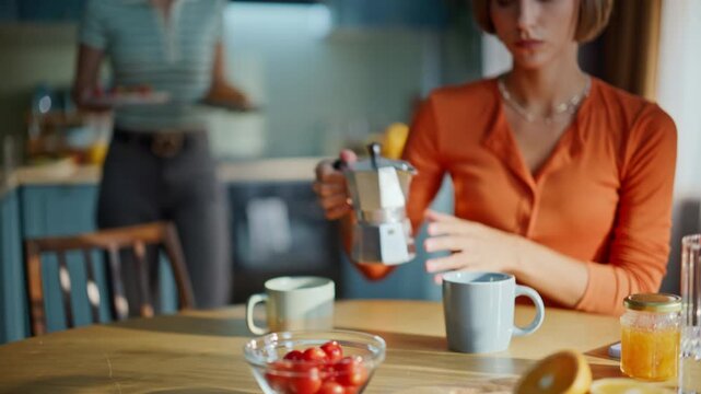 Lady hand taking coffeemaker filling cup for breakfast with sister home closeup.