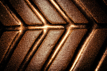 Gold coloured clay pot with line pattern and highlights close up