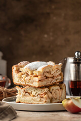 Homemade Apple Pie sliced sprinkled with powdered sugar on brown background. Thanksgiving traditional dessert, autumn baking, recipe. Copy space