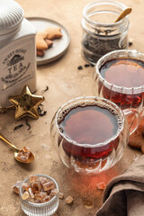Black tea in two transparent glass cups on brown textured table background. Cozy breakfast teatime