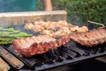 Meats and asparagus grilling on hot barbecue