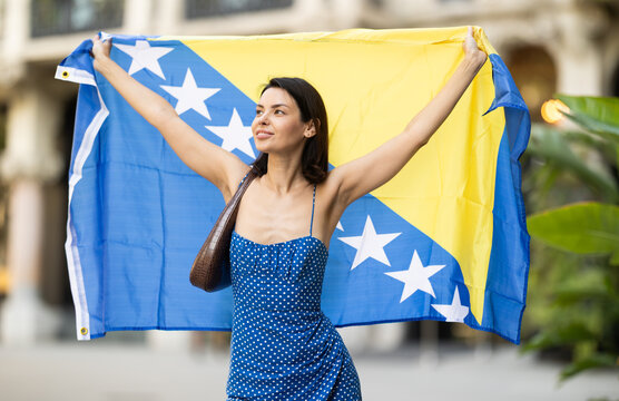 Young woman in summer dress with Bosnia and Herzegovina flag on city street