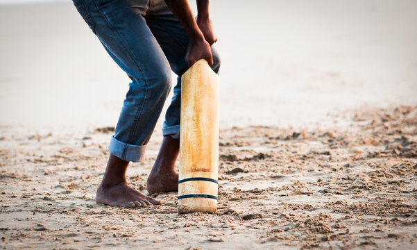 boy playing cricket on the beach - Powered by Adobe