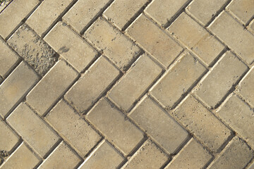 Piso de calçada com blocos de pedra cinza em padrão de ziguezague visto de cima