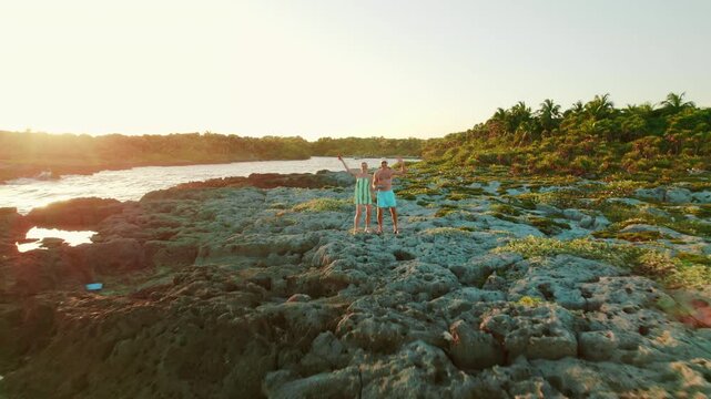 Couple exploring rocky shore at sunset near Crocodile lagoon, Akumal Mexico