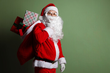 Santa Claus with bag of gifts on green background, space for text. Merry Christmas and Happy New Year