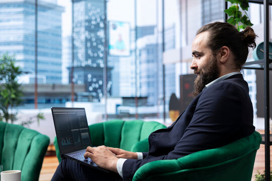 Goal oriented businessman in a high end corporate office plans a strategy to ensure company future, reviewing market research and tracking expenses. Obtaining corporate achievement.