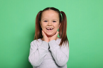Portrait of cute little girl on green background © New Africa