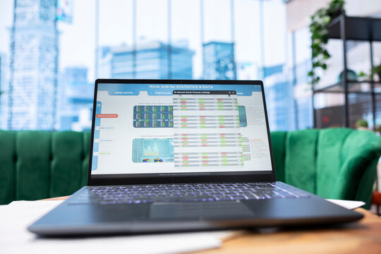 Modern work environment in a stylish skyscraper downtown building, high end workspace with business infographics trends running on laptop. Career development and growth, office life. - Powered by Adobe