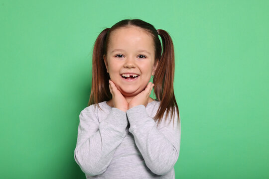 Portrait of cute little girl on green background