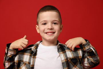 Portrait of cute little boy on red background